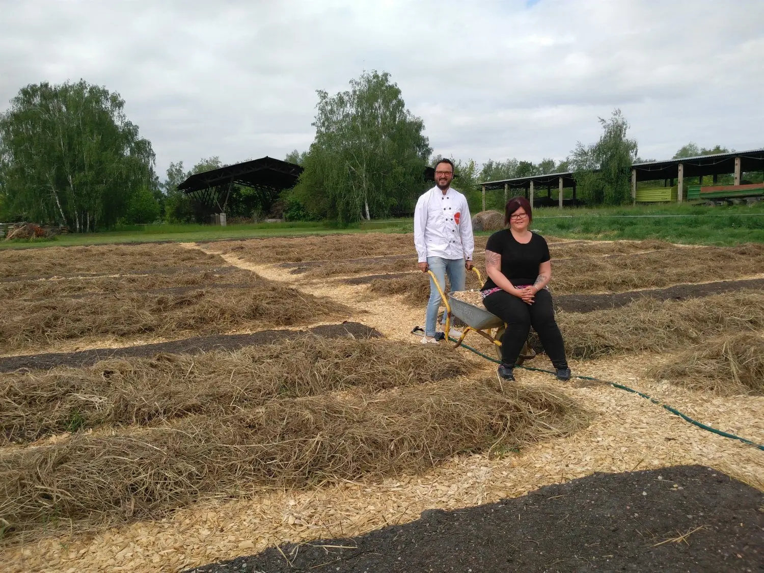 Restaurantleiter Jörg Thiele und Kellnerin Angie Schiemenz haben sichtlich Spaß: Sie bestellen derzeit auf einem Grundstück in Groß Beuchow 93 Beete und verteilen mit der Schubkarre Hackschnitzel für die Wege. Die dort angebauten Produkte sollen anschließend im Landwarenhaus und Restaurant des Schlosses angeboten werden.
