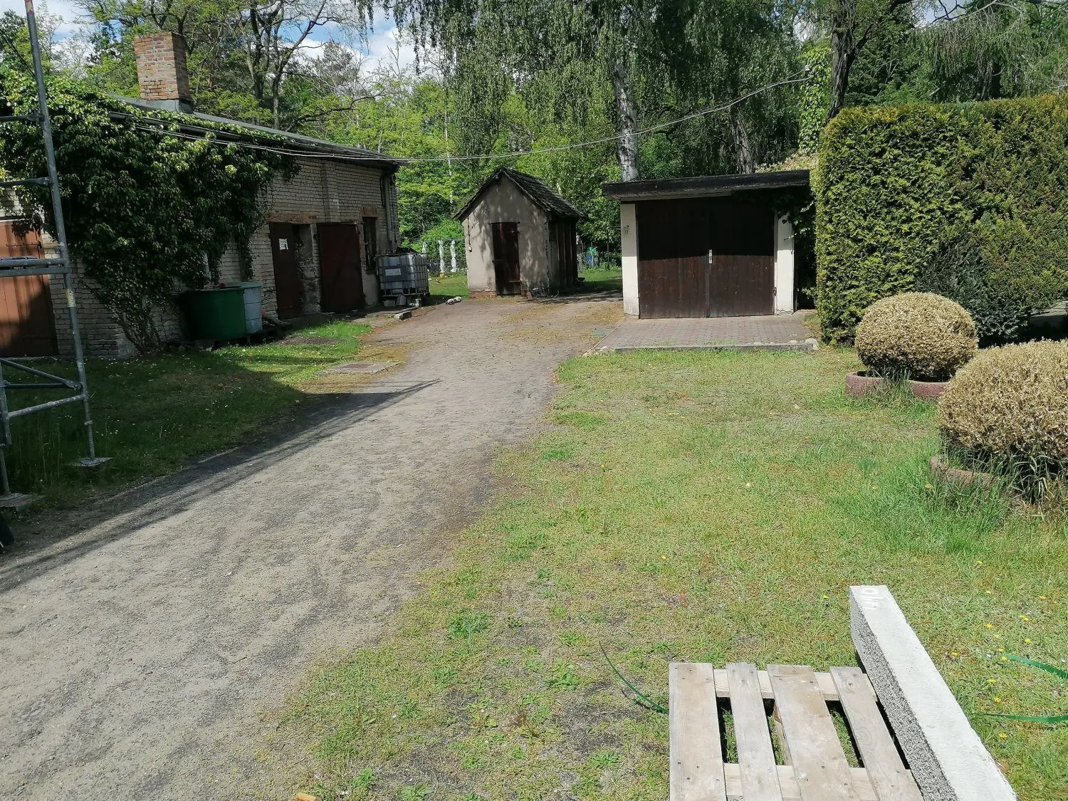 Mit Blick auf das Gesamtbild von Alwine macht dieses Nebengelass samt Hof neben dem Mehrfamilienhaus einen gepflegten Eindruck.