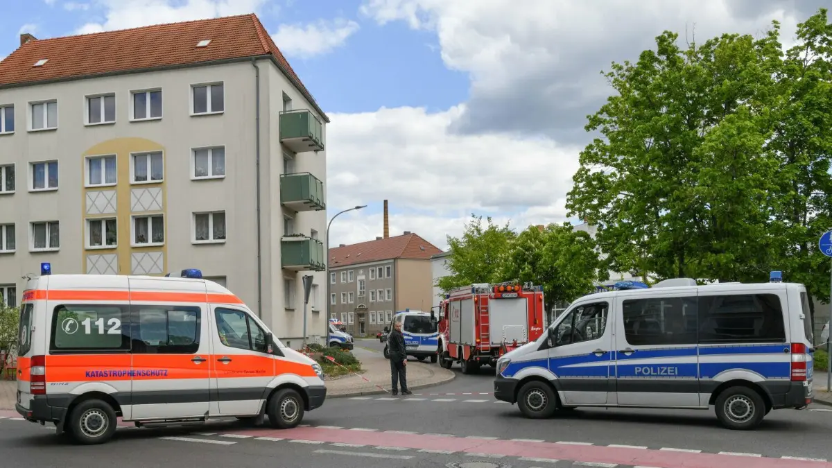 Forst im Mai 2019: Einsatzkräfte der Polizei, Feuerwehr und Katastrophenschutz stehen in der gesperrten Amtstraße. Zwei Männerleichen sind in einer Wohnung entdeckt worden. Bis heute sind der oder die Mörder unbekannt.
13.05.2019, Brandenburg, Forst: Einsatzkräfte der Polizei, Feuerwehr und Katastrophenschutz stehen in der gesperrten Amtstraße. Zwei Männerleichen sind in einer Wohnung in der südbrandenburgischen Kleinstadt Forst (Spree-Neiße) entdeckt worden. Nach derzeitigem Erkenntnisstand wird davon ausgegangen, dass die Männer Opfer eines Gewaltverbrechens wurden, wie ein Polizeisprecher mitteilte. Foto: Patrick Pleul/dpa-Zentralbild/dpa +++ dpa-Bildfunk +++