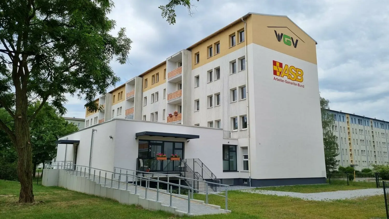 Anbau für die Tagespflege mit Außenbereich auf der Gebäuderückseite.