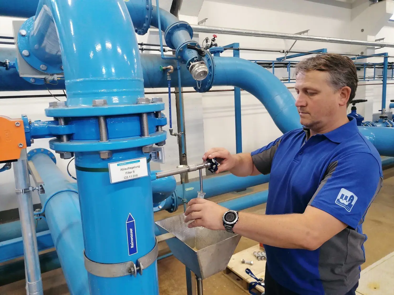 Wasser- und Netzmeister Heiko Pirschel nimmt an einem Filterablauf des Wasserwerkes Oschätzchen eine Wasserprobe. Dies hier ist kein Trinkwasser. Es enthält noch zu viel Mangan. Weitere Filterstufen sind erforderlich.
