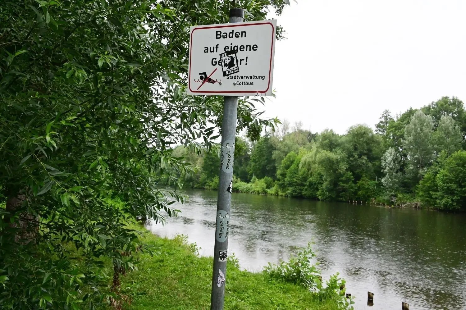 An der Badestelle an der Sanzebergbrücke in Cottbus-Sandow steht ein Hinweisschild: Baden auf eigene Gefahr! Immer wieder kommt es zu tödlichen Badeunfällen an Flüssen.