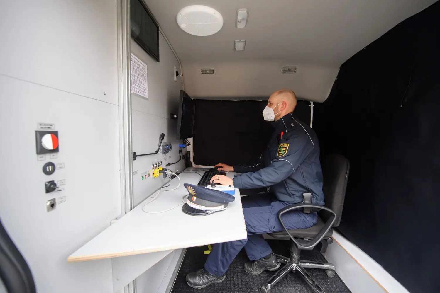 Ein Polizist der Soko Argus demonstriert in einem umgebauten Lieferwagen die Kamera-Laser-Einheit als Personenidentifizierungssystem.