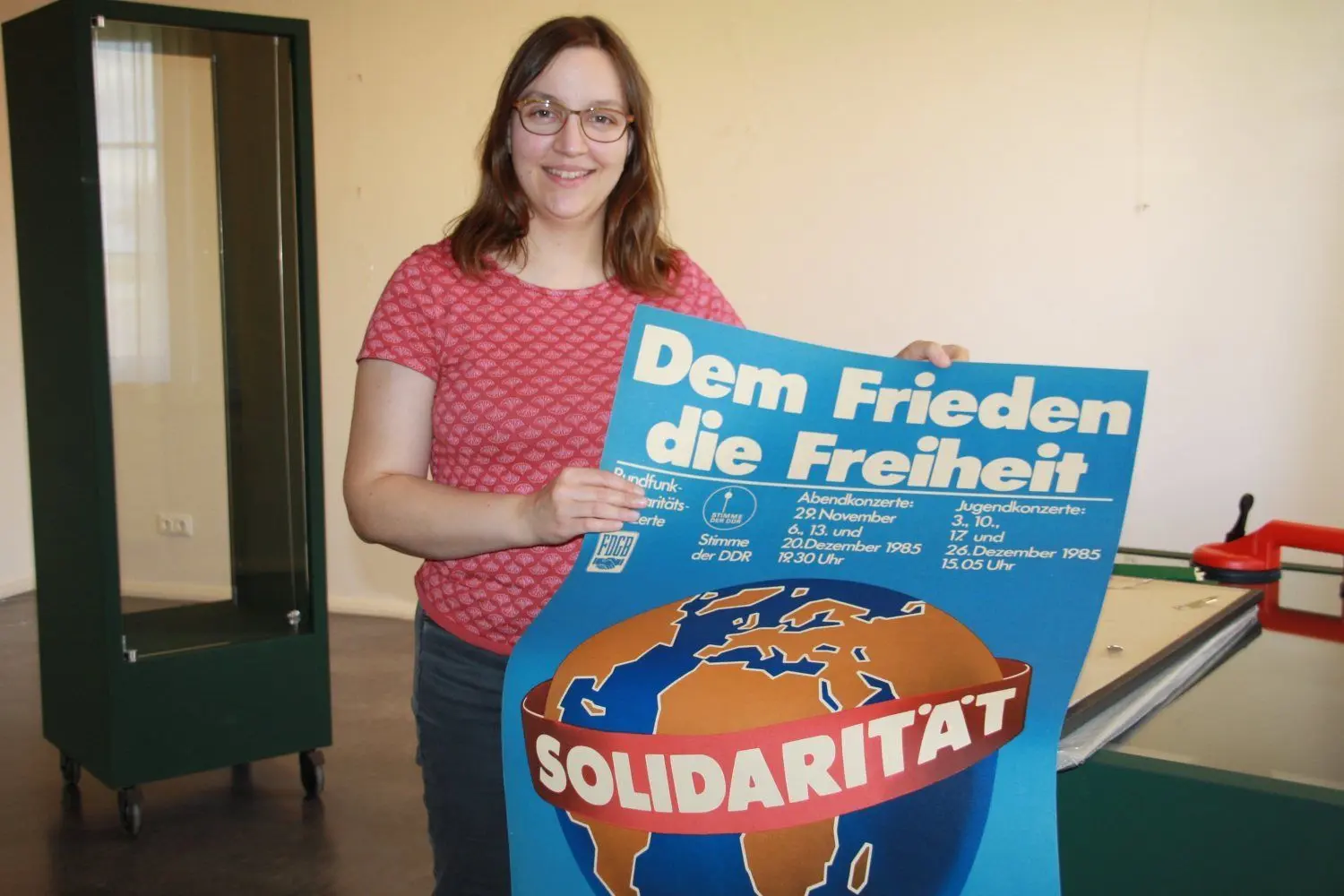 Marina Gadomski zeigt ein Plakat. Unter dem Slogan der antiimperialistischen Solidarität wurden beispielsweise junge Mosambikaner in die Region zu Landwirten ausgebildet.