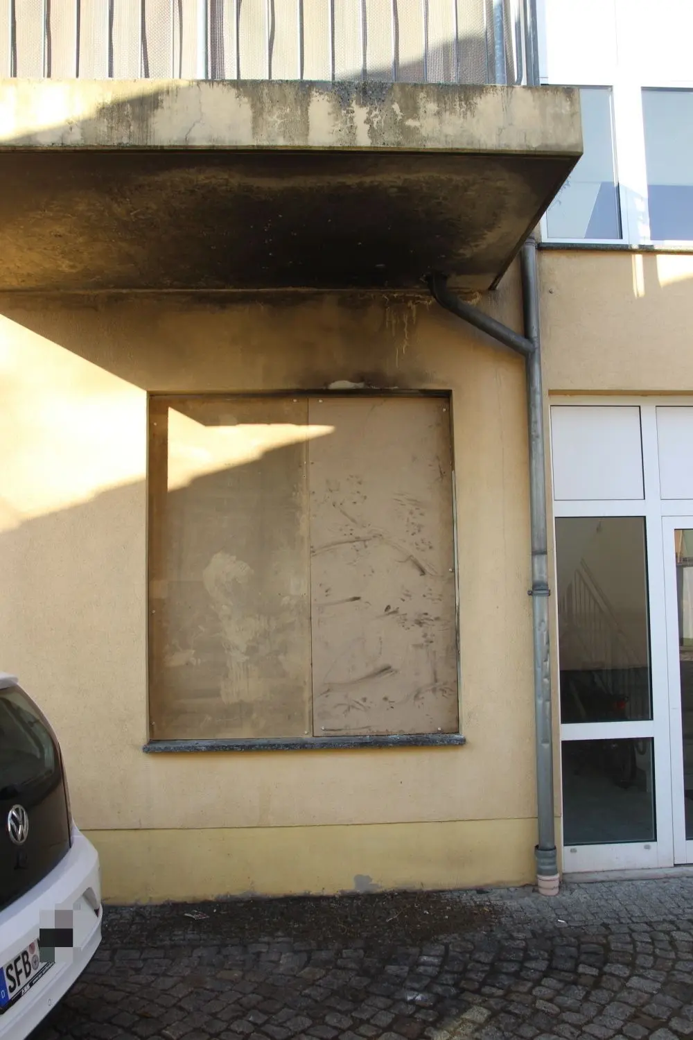Ein großes Fenster des Salons ist durch Holzplatten abgedichtet.
