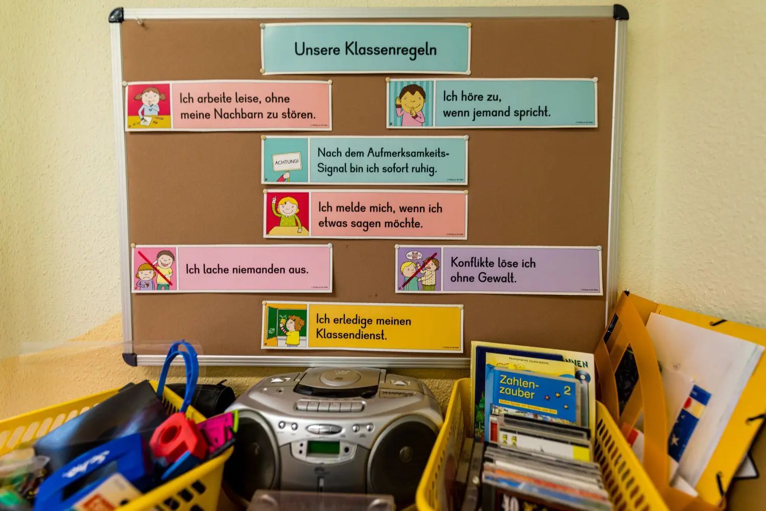 Eine Tafel mit Klassenregeln hängt an der Wand im Klassenzimmer einer zweiten Klasse.