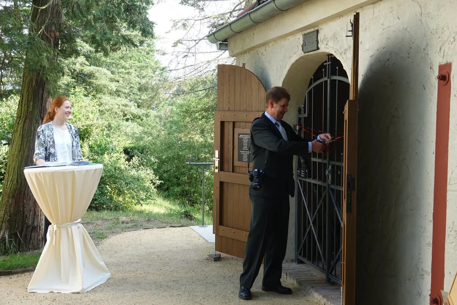 „Gruftbeauftragter“ Frank Dutsch darf das Band bei der Einweihung durchschneiden. Vorher hatte Pfarrerin Miriam Arndt Worte des Dankes an alle Beteiligten gefunden.