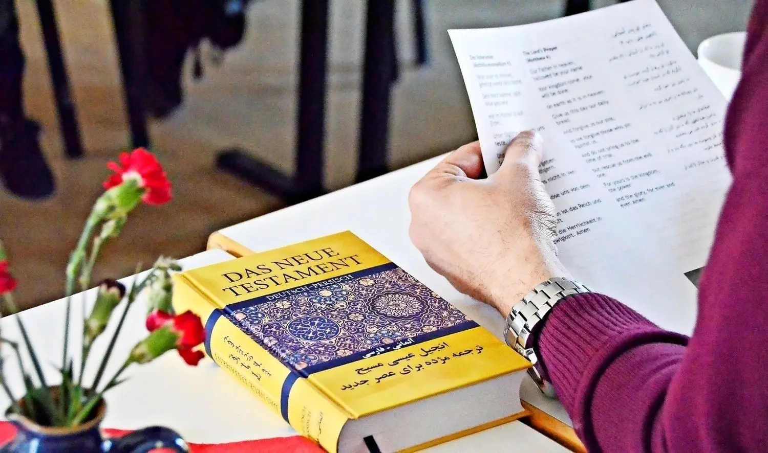 Liegt beim Taufkurs für Asylbewerber an jedem Platz: das Neue Testament in Deutsch und in Persisch.