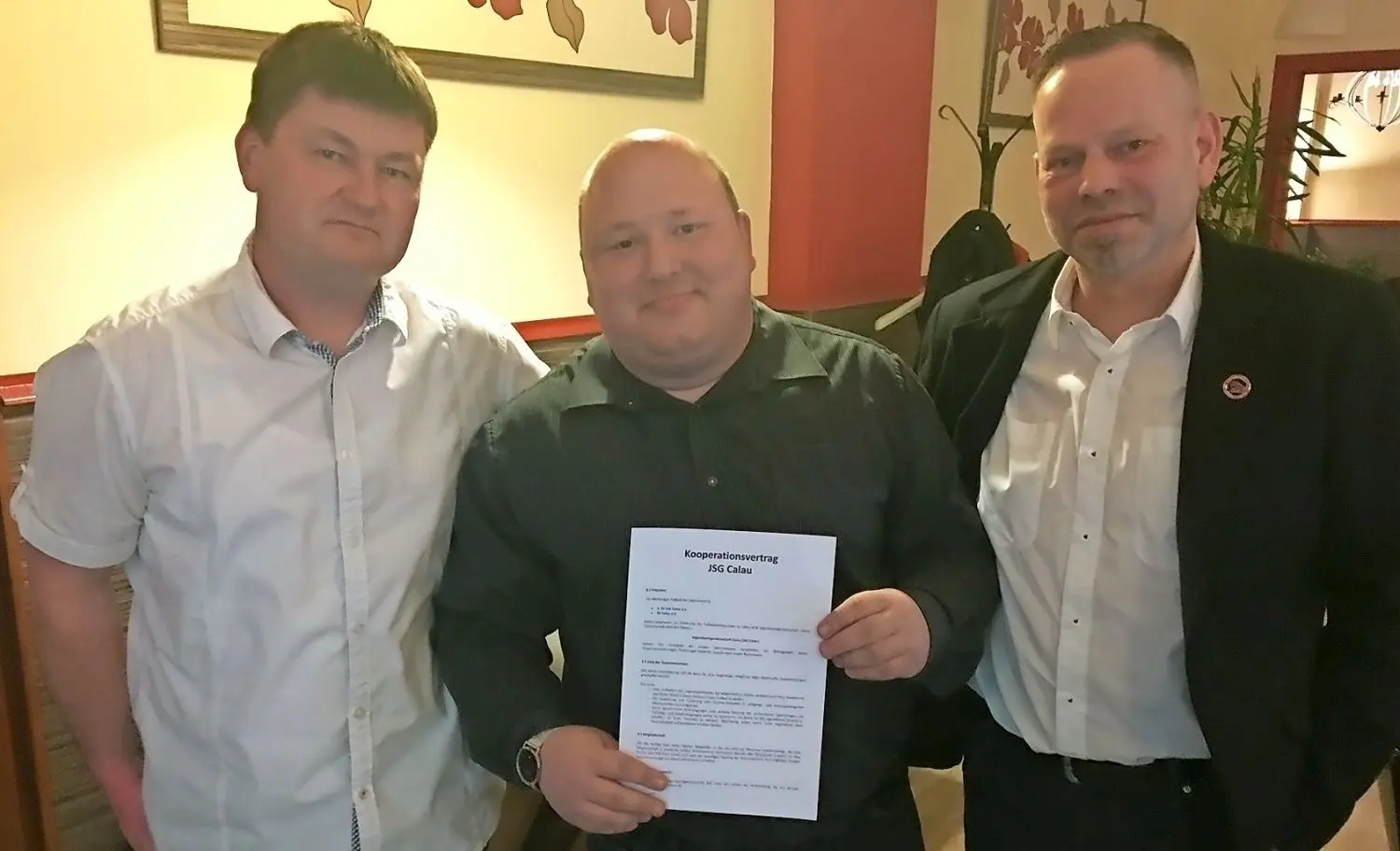 Toni Kasper (M.), neuer Leiter der Jugendspielgemeinschaft Calau, zeigt voller Stolz im Hotel zur Post den soeben unterschriebenen neuen Kooperationsvertrag. Flankiert wird er von Torsten Schreiber, dem Präsidenten des 1. SV Lok Calau (r.) und Patrick Karzenburg, Präsident vom SV Calau (l.). ⇥