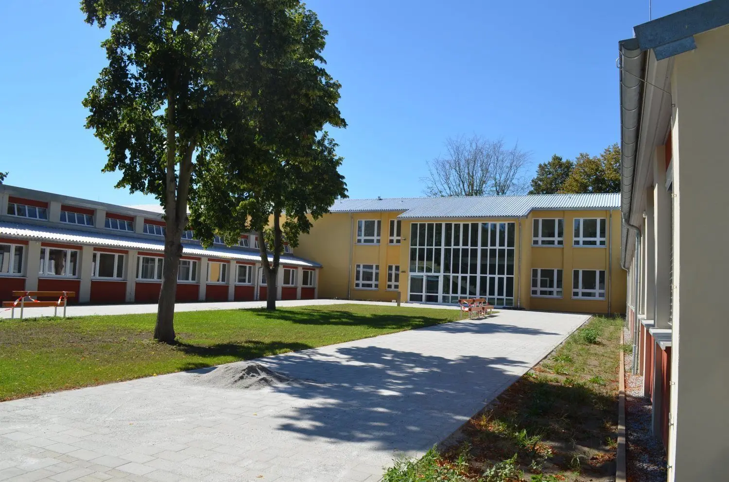 Die neue Hoyerswerdaer Oberschule: Die Pavillons sind in rot gehalten, der Altbau in gelb – nach historischem Vorbild. Die Schule war einst die erste der Hoyerswerdaer Neustadt.