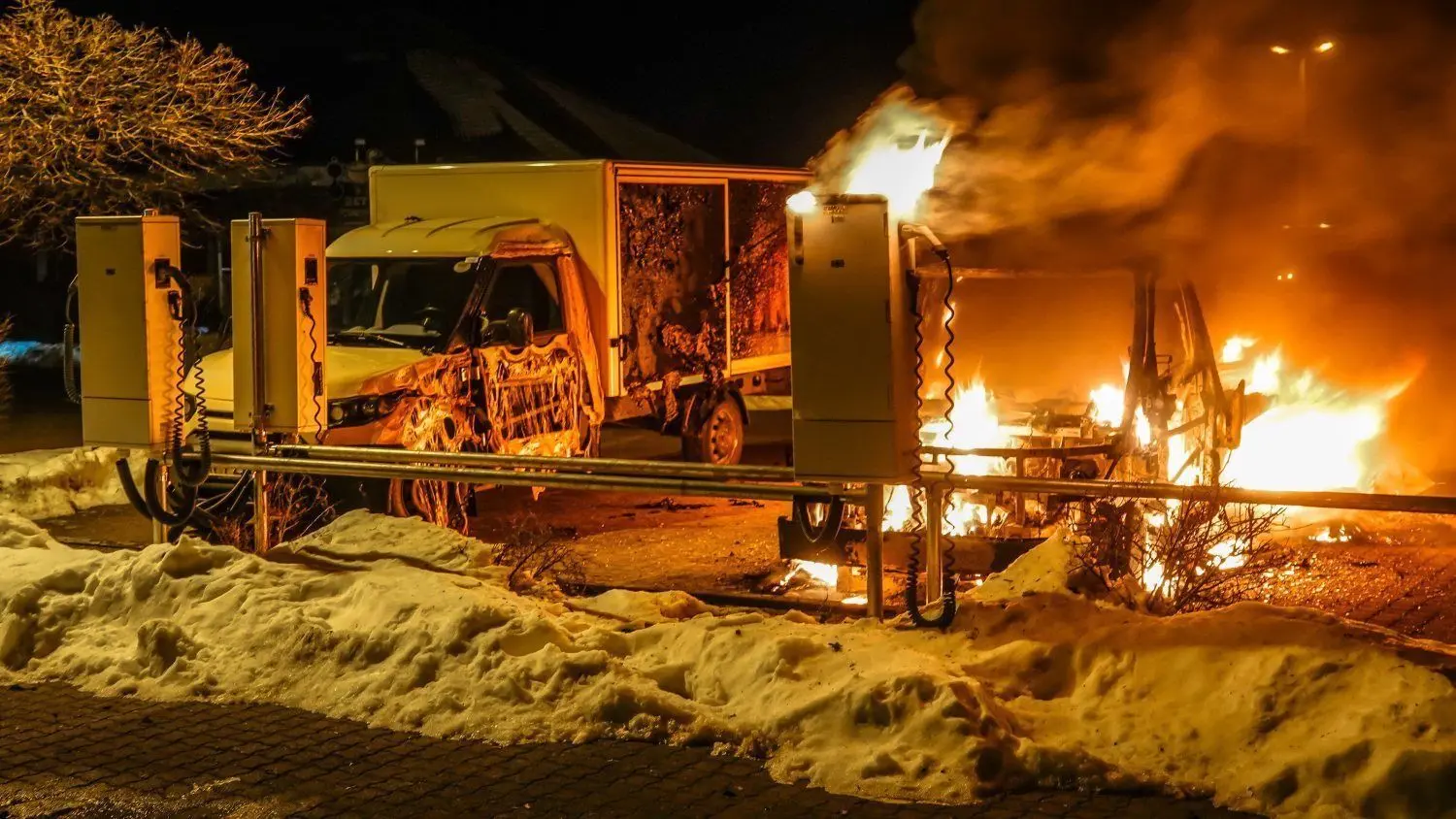 Ein Elektroauto der Post brennt auf einem Parkplatz in Bad Liebenwerda ab. Das daneben stehende wird erheblich beschädigt.