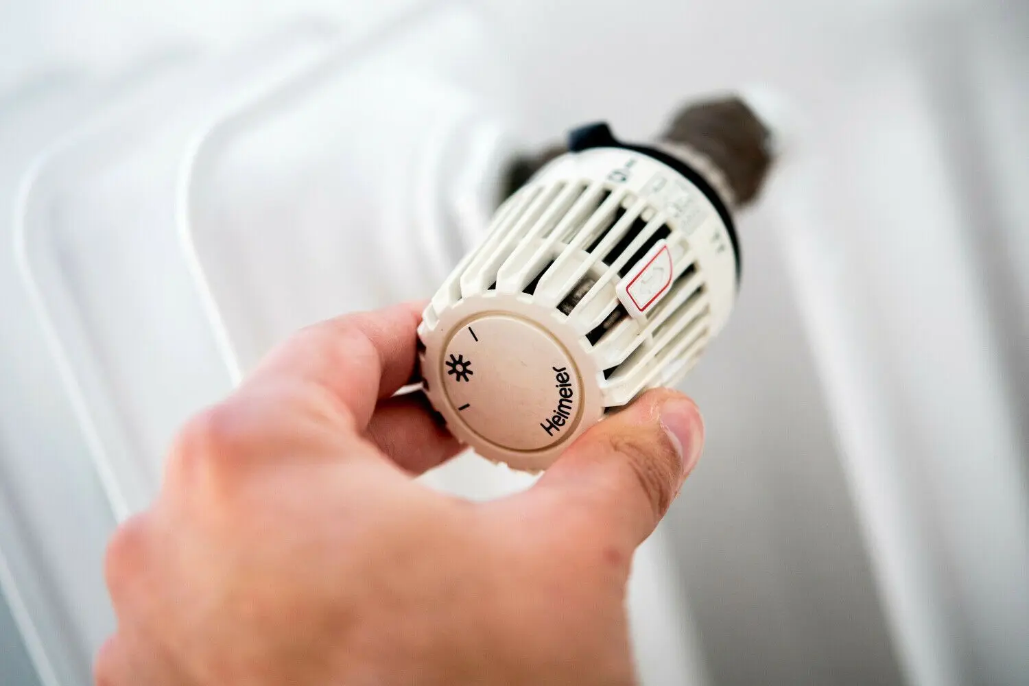 Ein Mann dreht in einer Wohnung am Thermostat einer Heizung. Die Stadt Hoyerswerda prüft jetzt, in welchen öffentlichen Gebäuden Energie gespart werde kann. (Symbolfoto)