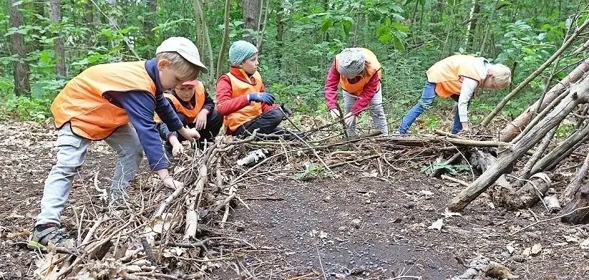 Bude bauen im Wald. Die Schwarzheider Waldkinder sind eifrig bei der Sache. Das Werkzeug finden sie in der Natur. ⇥