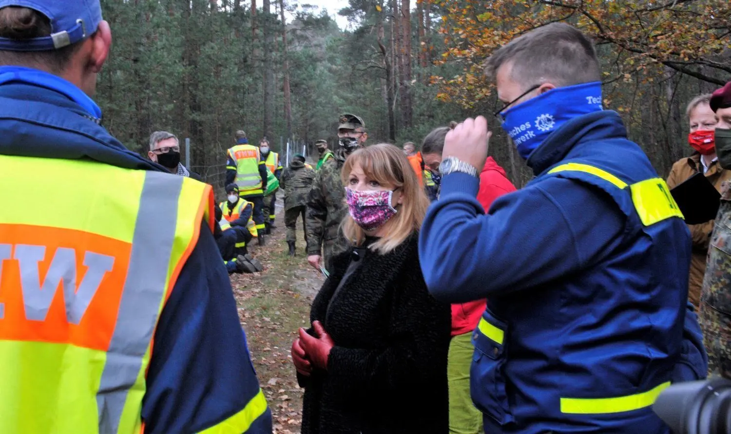 Mitarbeiter des THW, Benjamin Schulze und Andreas Heinrich erklären Petra Köpping, wie de Zaun aufgebaut wird.