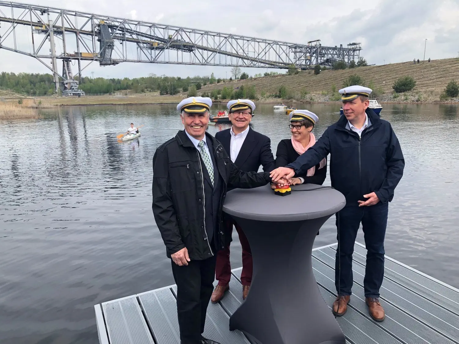 Das Warten hat sich gelohnt: Die Motor- und Paddelboote im Hintergrund warten darauf endlich über den Bergheider See zu fahren. Ditmar Gurk, Gottfried Richter, Heidrun Lochmann und Christian-Heinrich Jaschinski (v.l.) geben das symbolische Startsignal.