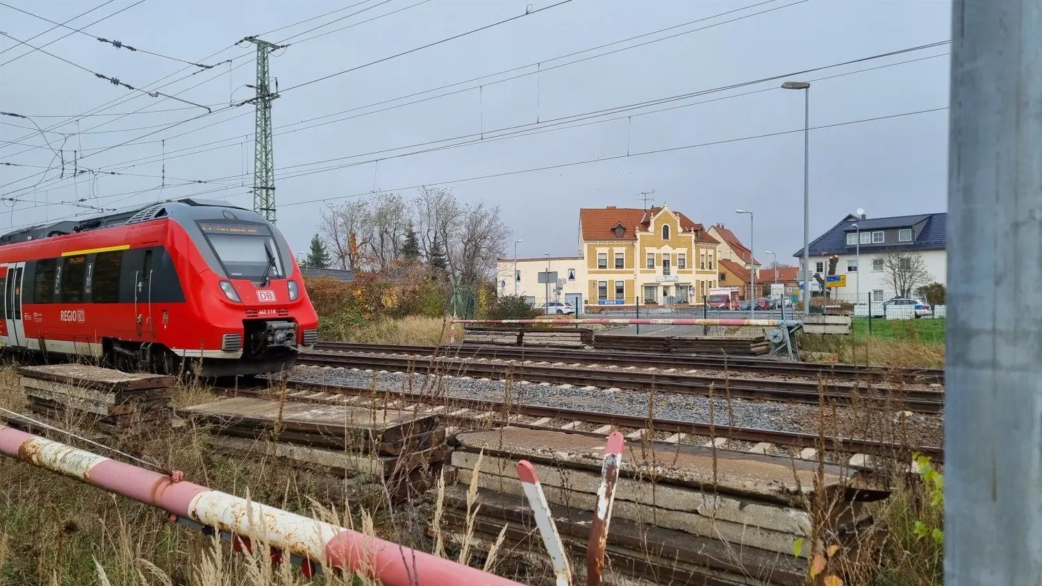 Stillgelegter Bahnübergang zwischen Straße des Friedens und Karl-Marx-Straße (Bildhintergrund). Hier ist für die schrankenlose Querung ein Tunnelbau vorgesehen.