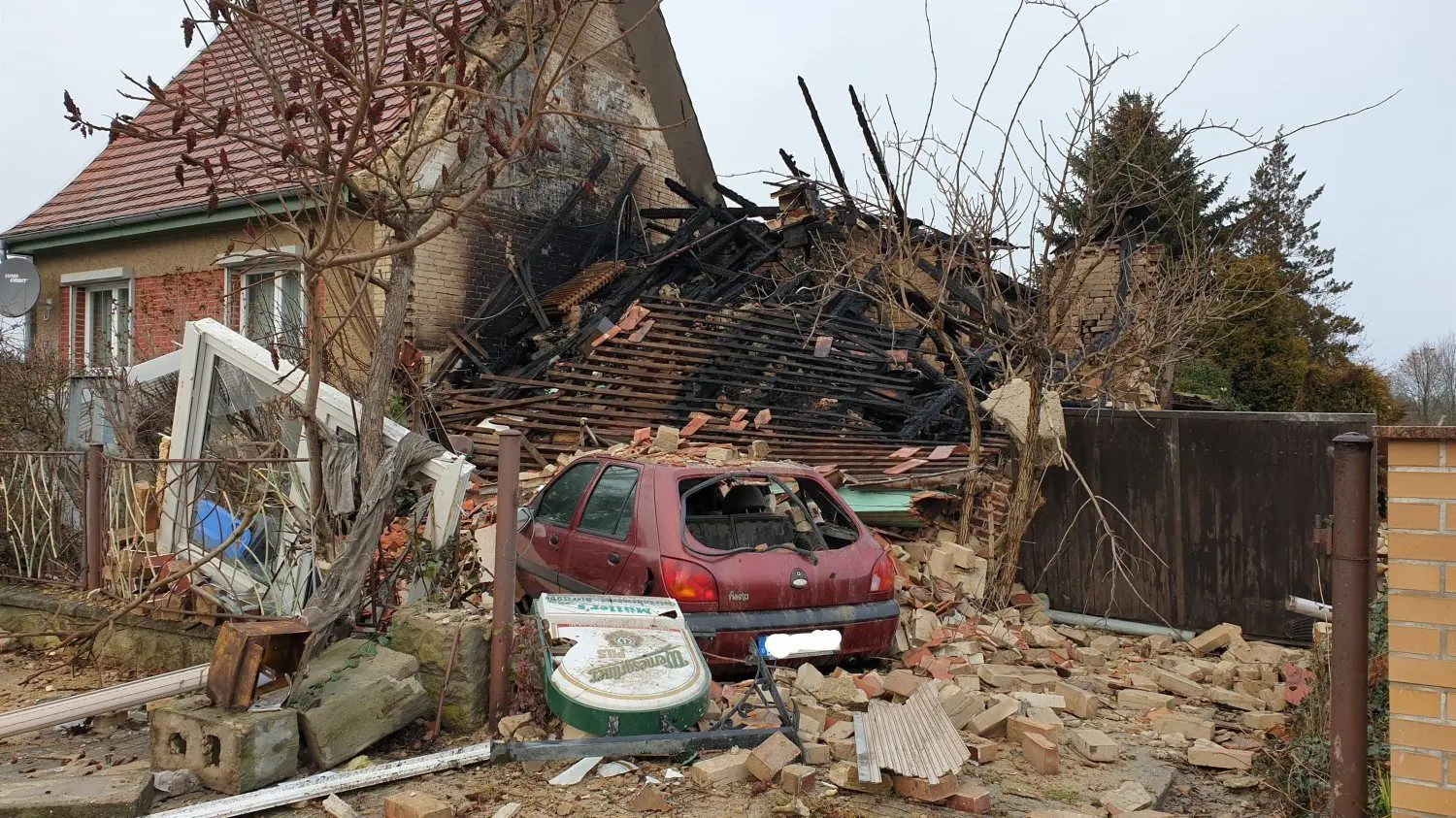 Der Schauplatz des Unglücks an der Schacksdorfer Straße 24 Stunden nach dem Großeinsatz der Feuerwehr und vieler weiterer Helfer: Die Doppelhaushälfte ist völlig zerstört. Auch ein Kleinwagen ist schwer beschädigt worden.