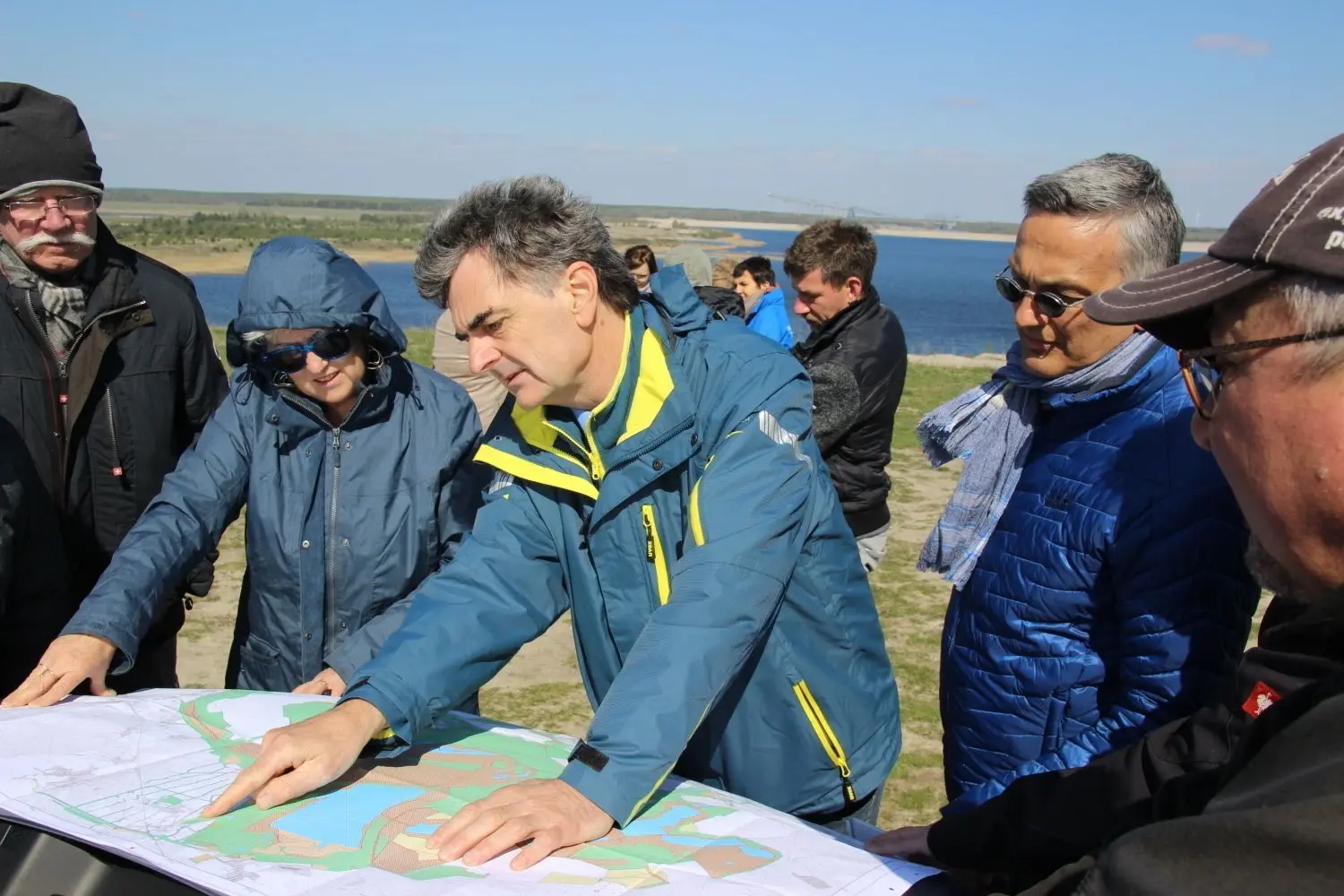 LBV-Manager Frank Sauer (M.) erklärt die Entstehung des Bergheider Sees durch den Tagebau Klettwitz-Nord.