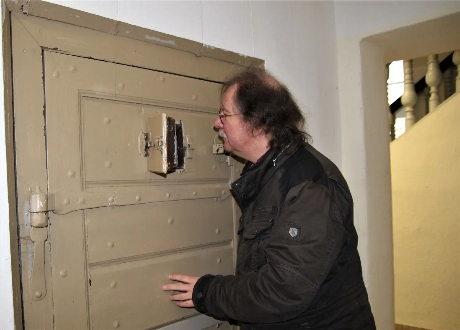 Einen Häftling kann der Spremberger Museumsleiter Eckbert Kwast durch das kleine Fenster in der einzigen im Schloss verbliebenen Zellentür nicht mehr erspähen, aber Putzmittel und abgestelltes Mobiliar.