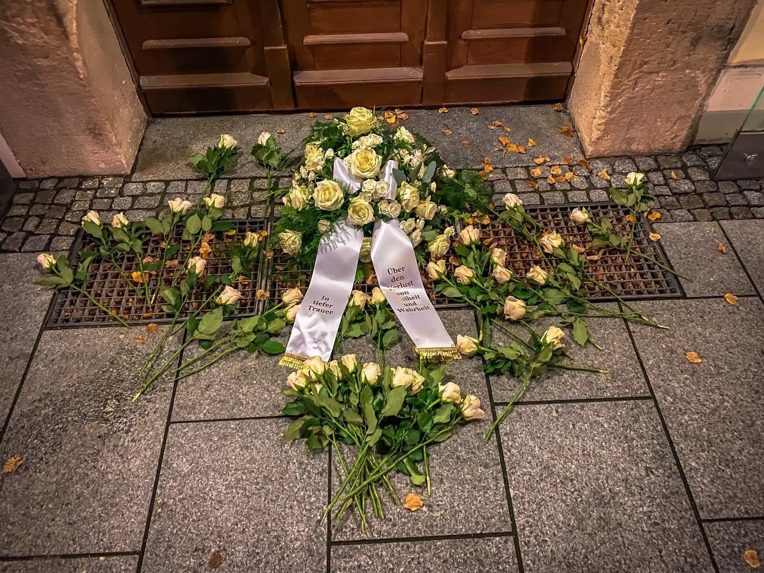 Vor dem Rathaus in Bad Liebenwerda ist dieses Blumengebinde mit der Aufschrift "In tiefer Trauer - Über den Verlust von Freiheit und Wahrheit" abgelegt worden.