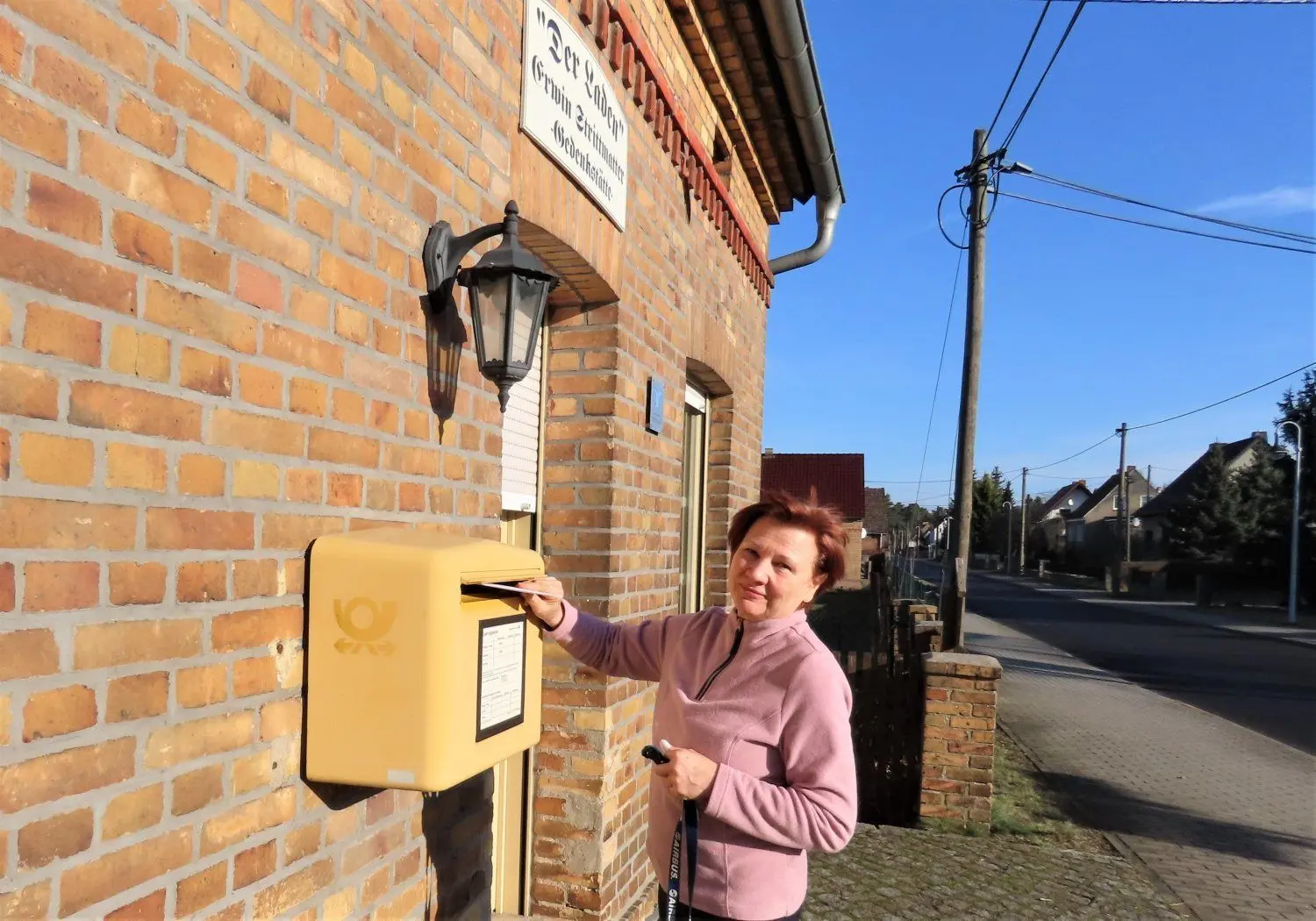 Petra Krautzig ist froh, dass es den Briefkasten in Bohsdorf am Strittmatter-Laden noch gibt. Diesmal schickt sie eine Geburtstagskarte an ihre Tante auf die Reise.