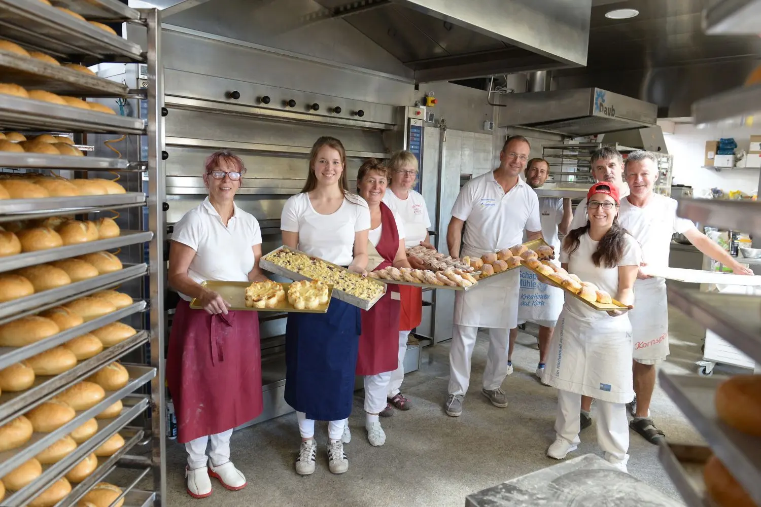 In der Backstube herrscht wieder Betrieb. Dienstag, Punkt 1 Uhr, wurde der neue Backofen angefeuert. Die 20-köpfige Mannschaft von Bäckermeister Axel Günther (Mitte) ist bei der Neueröffnung wieder komplett da. Alle haben während der siebenmonatigen Zwangspause ihrem Chef die Treue gehalten. ⇥