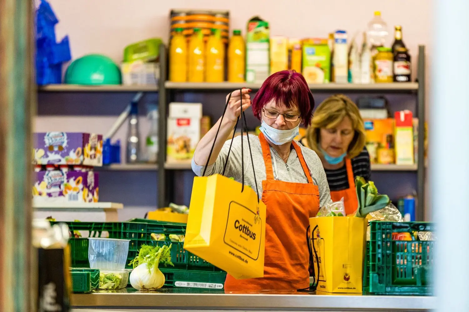 Hannelore Raak und Astrid Richter (v.r.) verpacken Lebensmittel für die Ausgabe an Bedürftige.