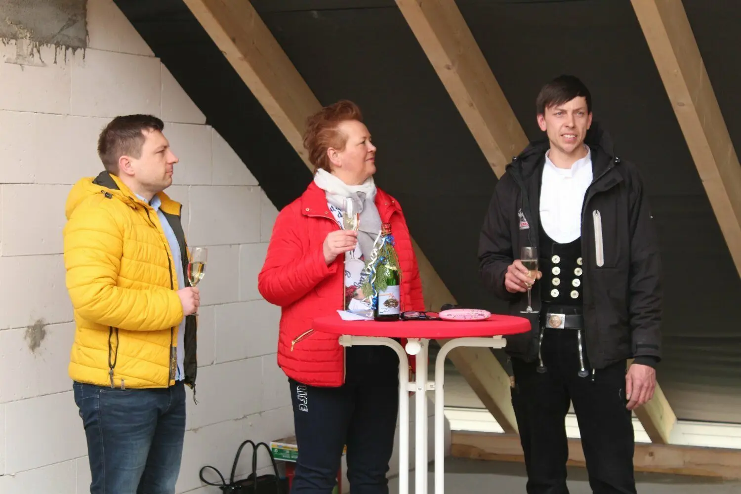 Zum Richtfest für den Neubau in Boxberg hält Zimmermann Stefan Kotz den Richtspruch. WBG-Chefin Petra Sczesny und Bürgermeister Hendryk Balko lauschen.