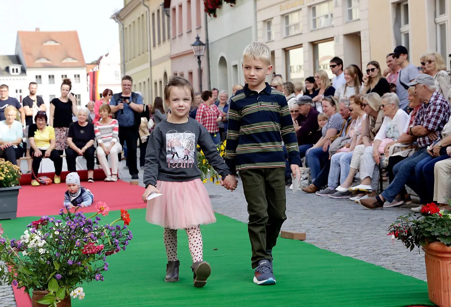 Kindermode präsentierten die Jüngsten auf dem Laufsteg-Teppich in der Hauptstraße. Dabei empfahl sich h ein noch jüngeres Nachwuchsmodel schon mal für kommende Jahre.