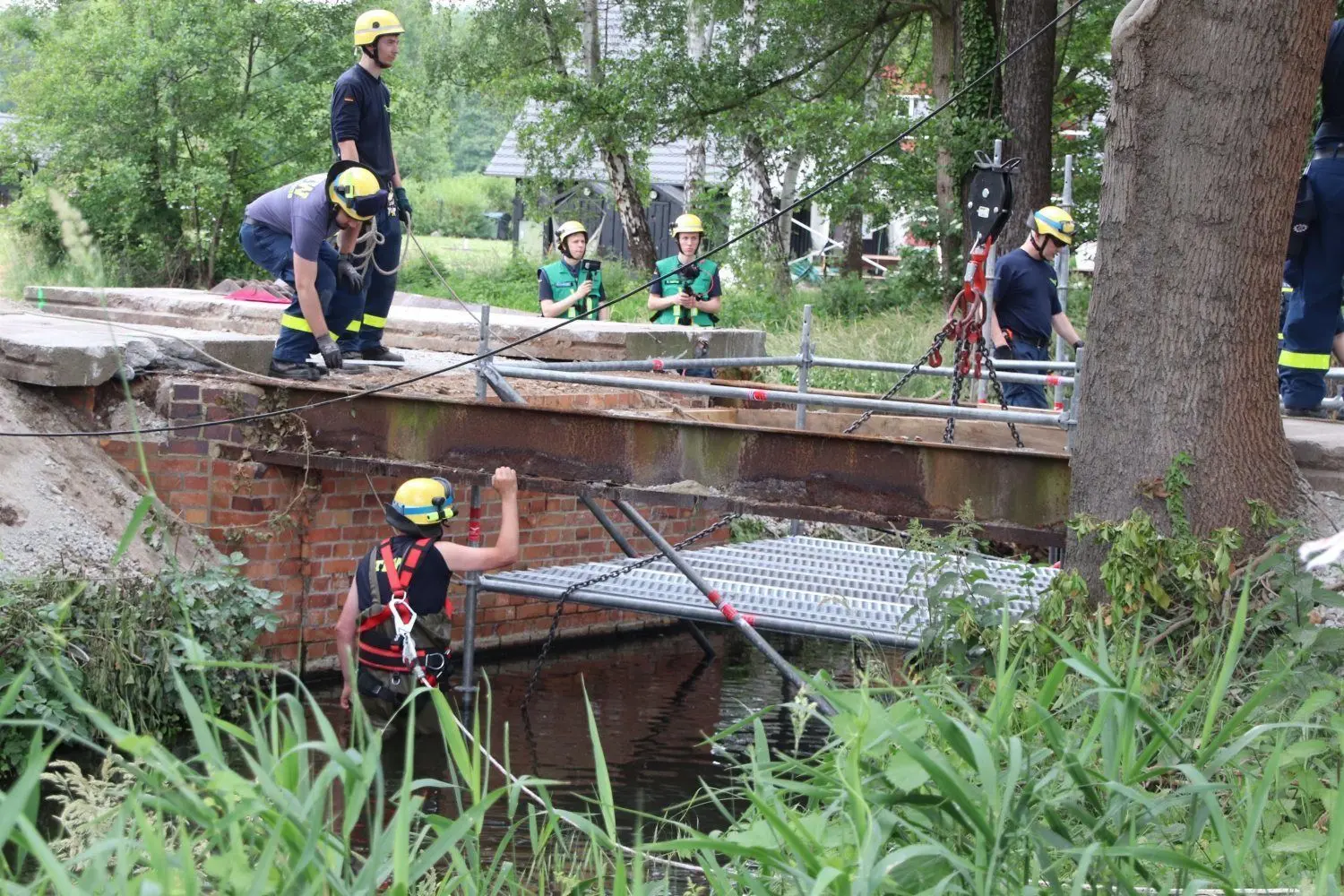 Das Hilfsgerüst im Bett des Stillen Fließes zu platzieren, ist eine Herausforderung. Die Einsatzkräfte, die im Wasser arbeiten, müssen gesichert werden.