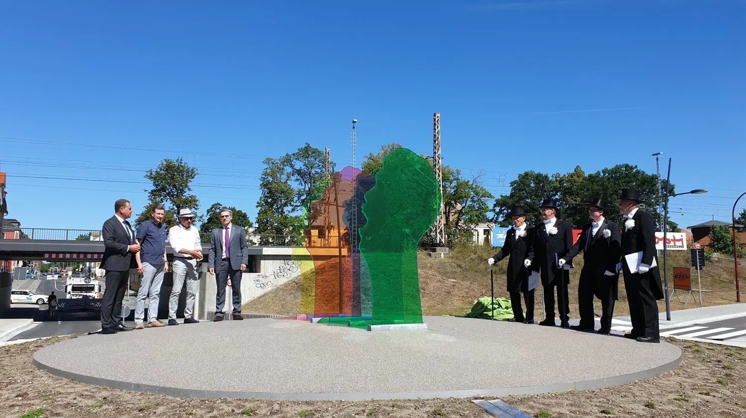 Baustaatssekretär Rainer Genilke, Stadtverordnetenvorsteher Andreas Holfeld, Künstler und Architekt Ararat Haydeyan und Sängerstadt-Bürgermeister Jörg Gampe nehmen gemeinsam mit den Vier Finsterwalder Sängern Aufstellung vor dem neuen Kunstwerk, das künftig Bürger und Gäste der Stadt begrüßt.