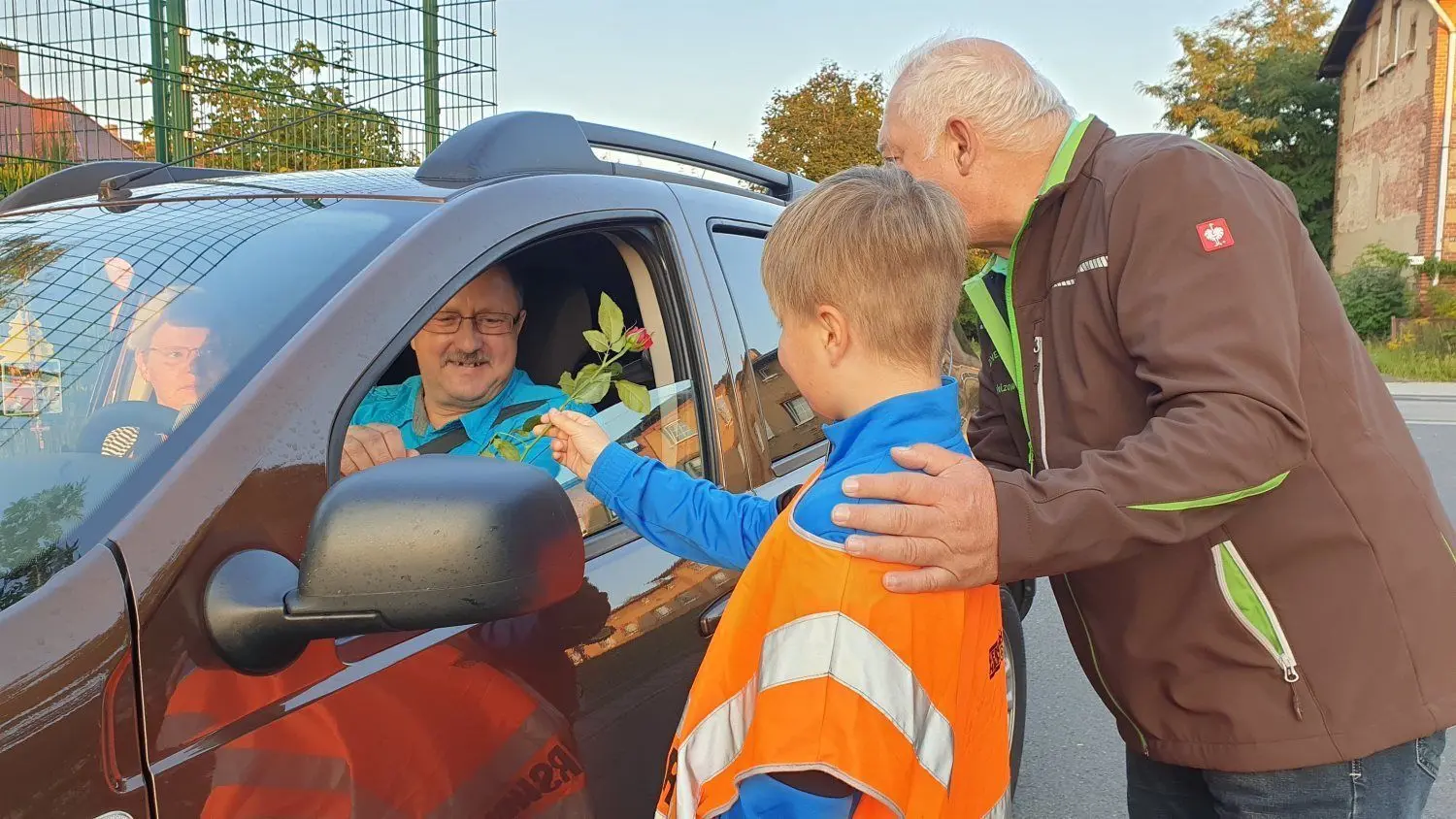 Thorsten Stange (r.) überreicht mit einem Welzower Schülerlotsen eine Rose. Der Autofahrer war vor der Goethe-Grundschule im Tempolimit 30 geblieben.