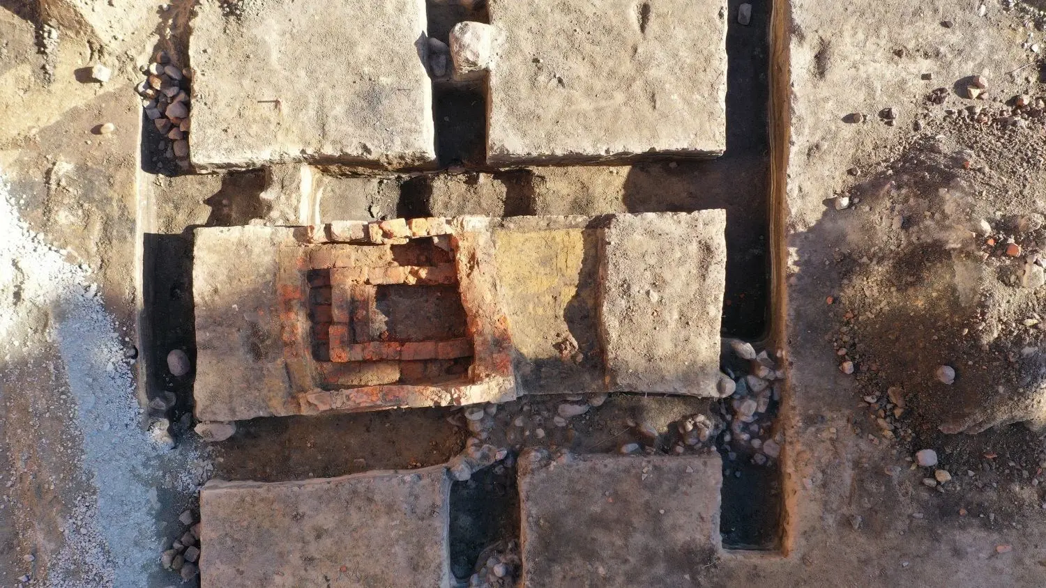 Die Mauerreste aus Ziegelsteinen (Mitte) des Ofens sind deutlich erkennbar. Die Gräben und das Innere werden in den kommenden Tagen mit Flüssigboden verfüllt, um den Fund für die Nachwelt zu erhalten.