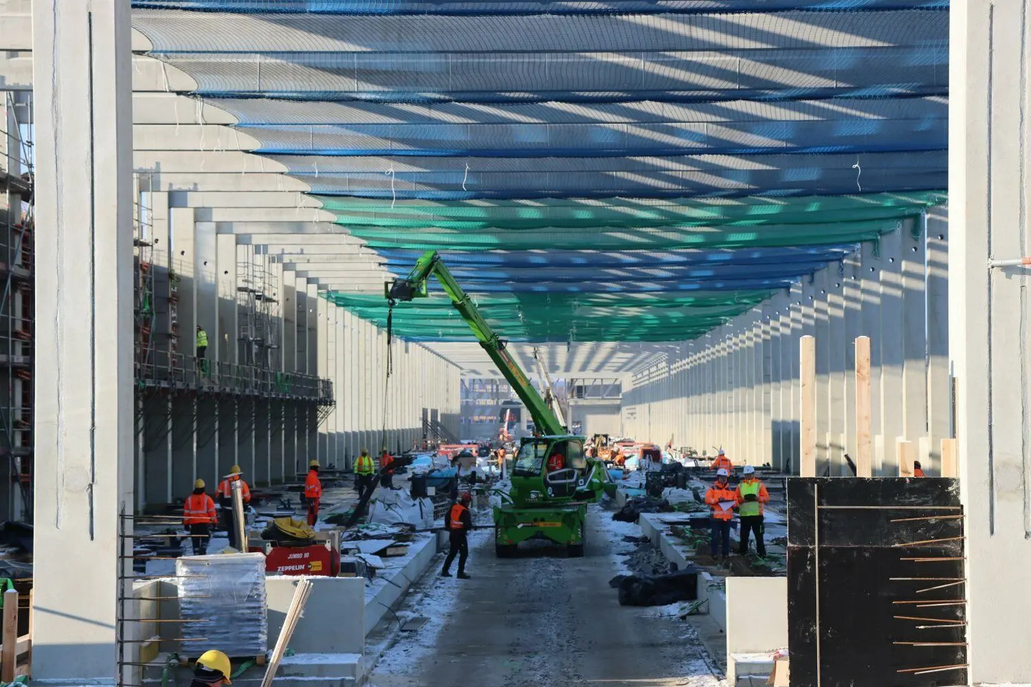 Unter dem Sicherheitsnetz für die Dacharbeiten läuft parallel der Innenausbau der neuen Halle.