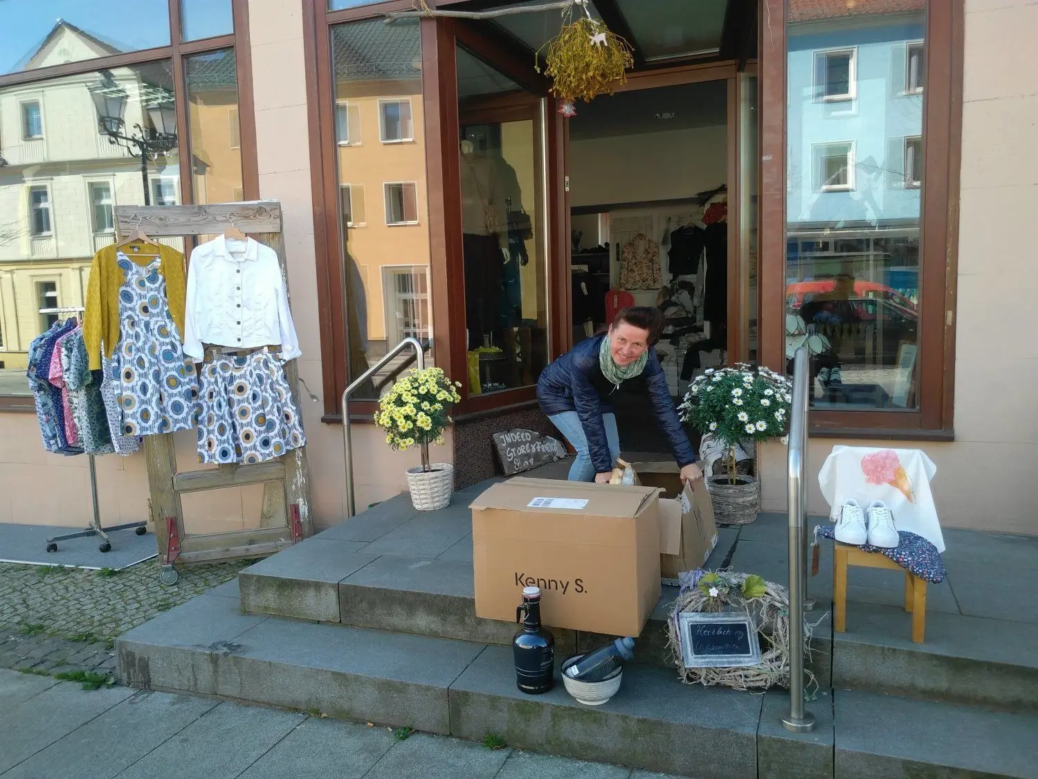 Monika Lux vom Modefachgeschäft Indeed in Calau räumt Kisten in ihren Laden, den sie am Mittwoch wieder öffnen durfte. Für sie sei es nun eine Herausforderung, "ein stehendes Rad wieder in Bewegung zu setzen", sagt sie über die wirtschaftlichen Probleme einer ganzen Branche.