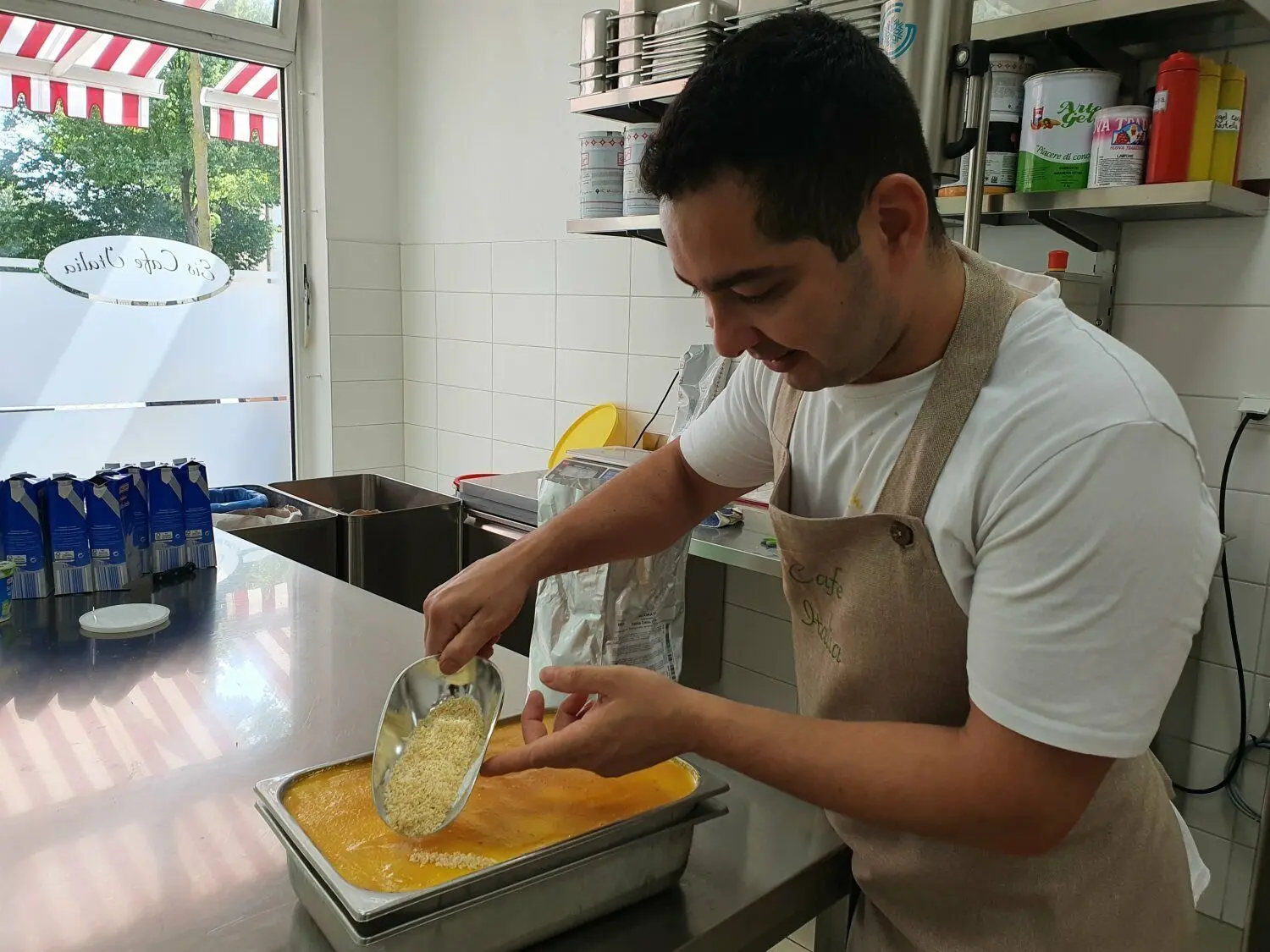 Das Auge isst mit: Marlon De Bona, Mitarbeiter im Familenbetrieb "Eiscafé Italia Senftenberg" in der Bahnhofstraße, dekoriert das Kokos-Mango-Eis mit Kokosraspeln.