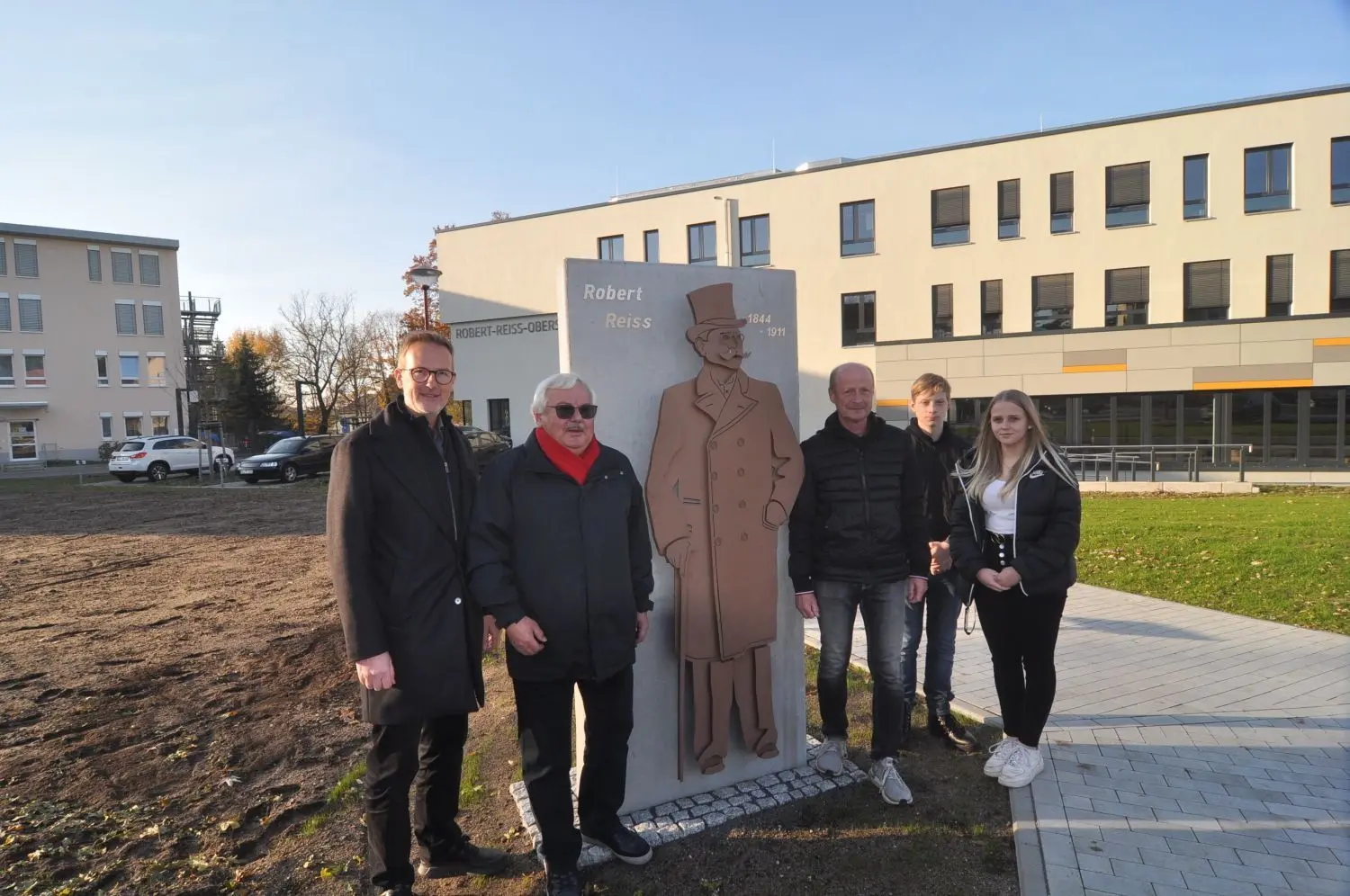 Aus Anlass des 110. Todestages ist die im Jahr 2007 eingeweihte und nun vor der neu gebauten Oberschule Robert Reiss anders platzierte, überarbeitete Stele des Firmengründers Robert Reiss übergeben worden. Dabei waren Reiss-Geschäftsführer Hans-Ulrich Weishaupt, der im Ruhestand befindliche einstige Geschäftsführer Dietmar Menzel, Schulleiter Hartmut Schmidt und Schüler der Oberschule (v.l.).