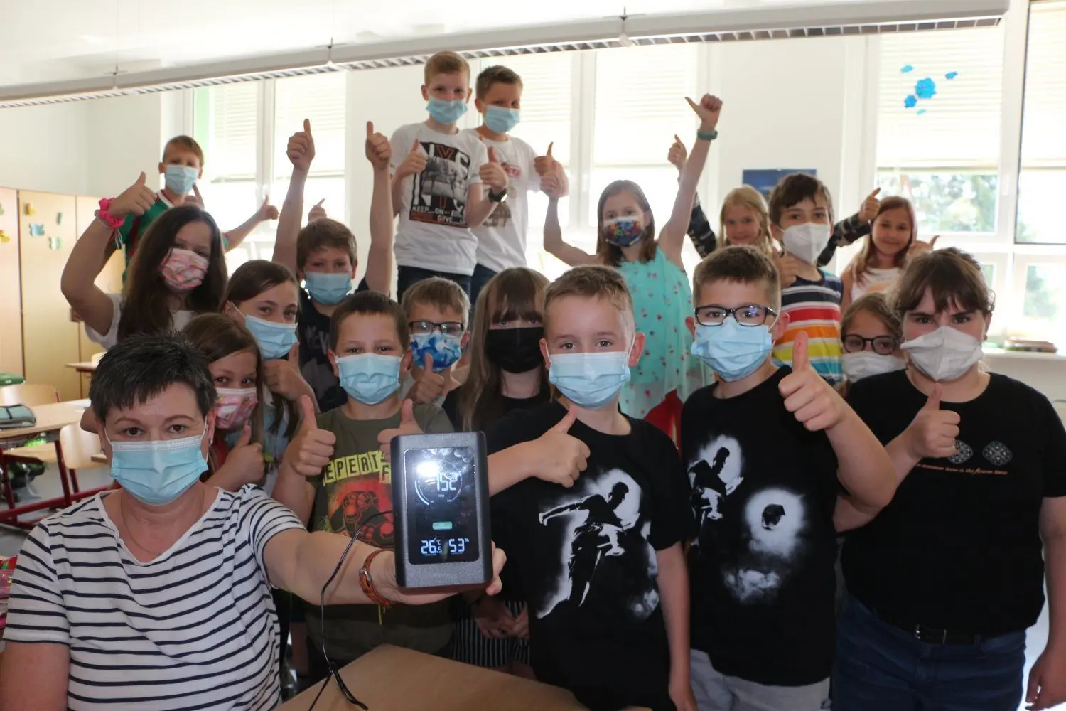 Daumen hoch: Bei den 23 Schülern, darunter neun Schülerinnen der vierten Klasse der Grundschule "Blauer Planet" kommt die neue CO2-Ampel gut an. Schulleiterin Katrin Piesk hält das innovative Gerät in die Kamera.