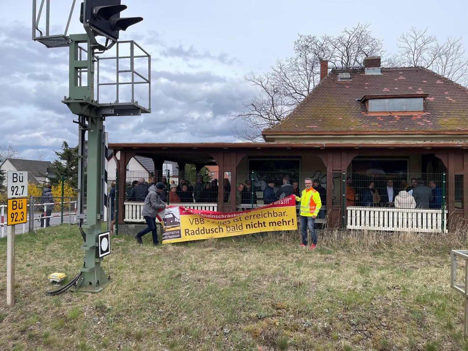 Thomas Noack und Matthias Hantscher (r.) legen am Bahnhof Raddusch das Protestplakat zusammen, es hat nach sieben Jahren seinen Zweck erfüllt.