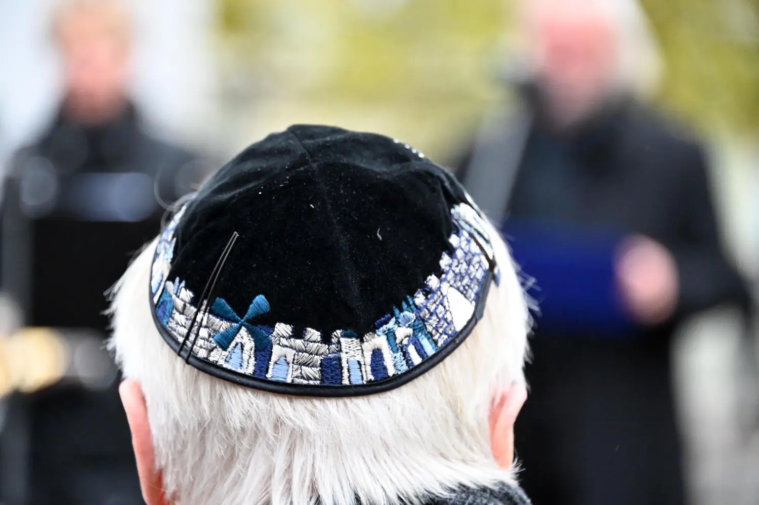 Auch jüdische Zuhörer lauschen vor der Synagoge der Namen von ermordeten Pogrom-Opfern.