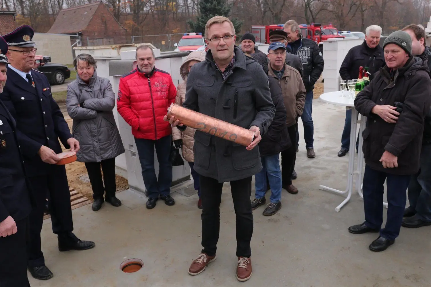 Bürgermeister Karsten Schreiber versenkt bei der Grundsteinlegung die Hülse mit Tages- und Wochenzeitung, Amtsblatt, Jahrbuch der Gemeinde und der Hänchener Chronik.