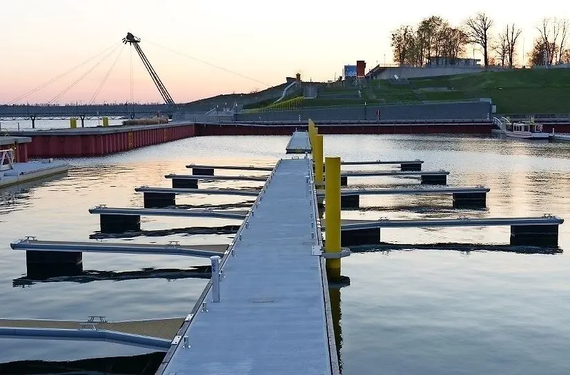 Hafenstimmung in der Abenddämmerung. Zwei Drittel der Fingerstege liegen bereits im Großräschener Hafenbecken. Zur Hafen-Ausstattung gehören auch ein fünfeinhalb Tonnen Auslegerkran und eine Slipanlage. ⇥