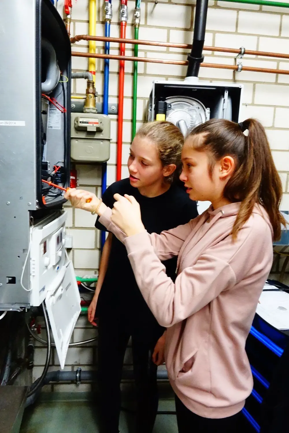 Emilia Gloß und Jette Jähde (r.) arbeiten an einem Gasbrennwertgerät.