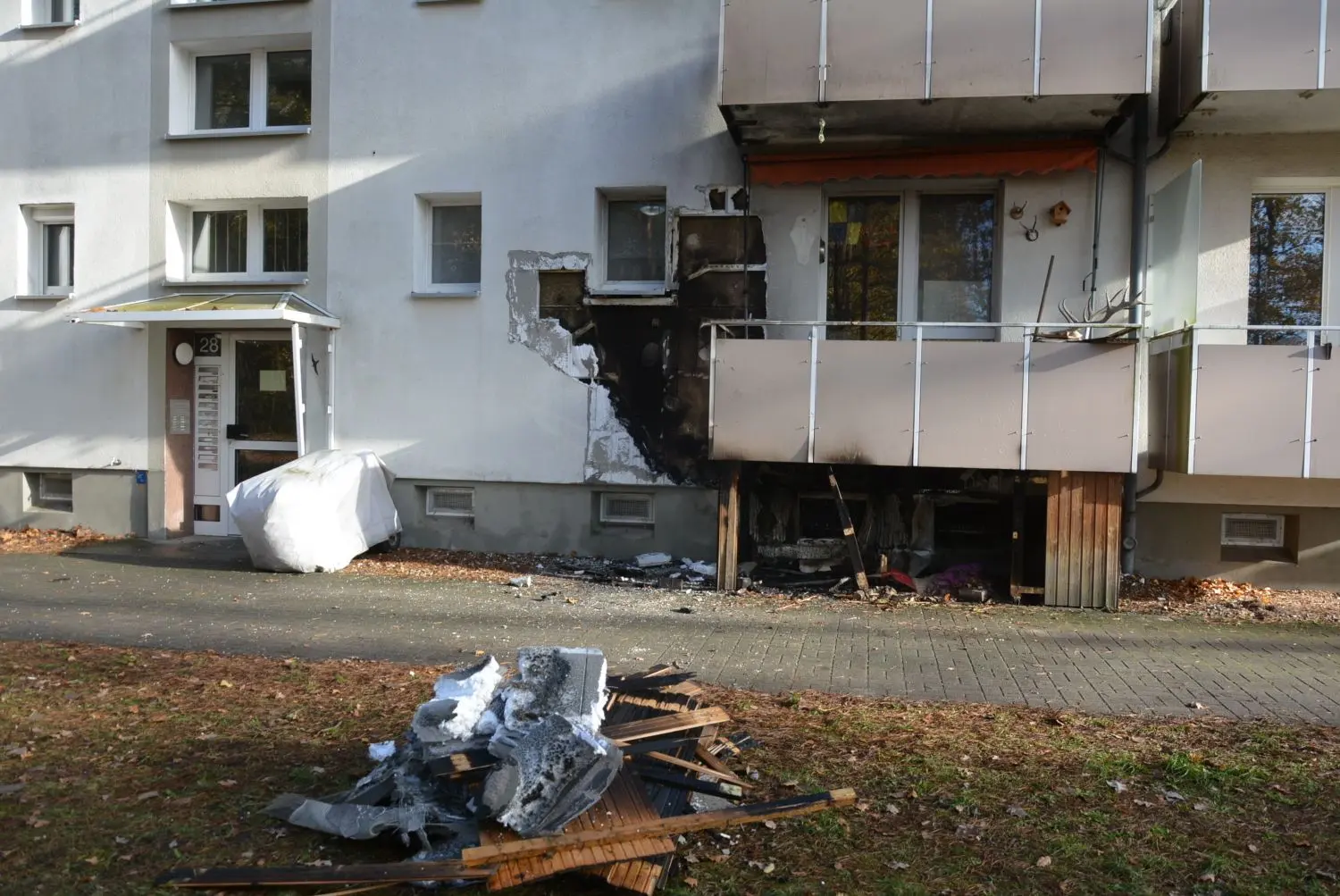 Ein großes Loch klafft nach dem Feuerwehr-Einsatz in der Fassade des Mehrfamilienhauses im Spremberger Ortsteil Trattendorf. Ein brennendes Elektro-Mobil hat das Gebäude beschädigt.