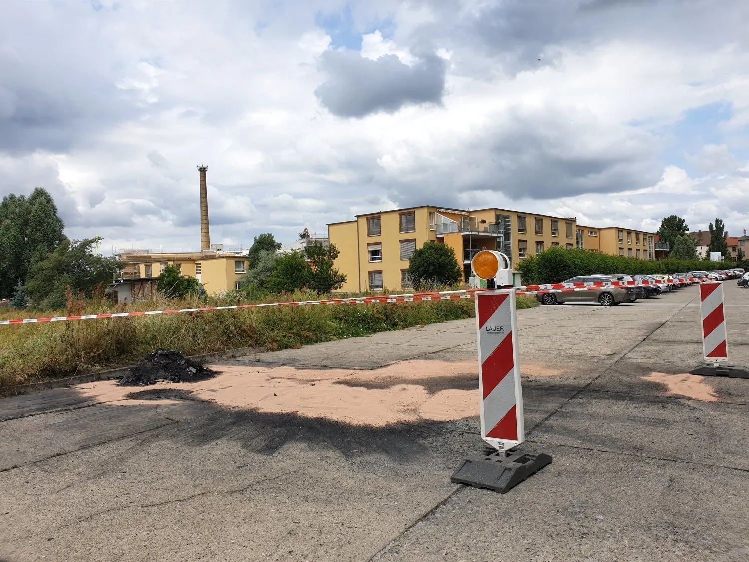 Der Einsatzort von Feuerwehr und Kripo auf dem Parkplatz nahe des Evangelischen Seniorenzentrums Am Schloss in Finsterwalde am Morgen des 15. Juli. In der Nacht zuvor war hier ein BMW in Brand geraten.