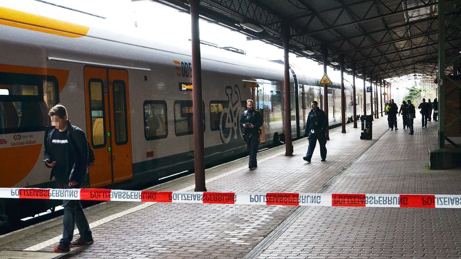 Mehrere Polizisten sind am Bahnhof in Guben im Einsatz. Nachdem eine junge Frau in einem Zug mit einem „axtähnlichen Gegenstand“ angegriffen wurde, wurde am Bahnhof ermittelt.