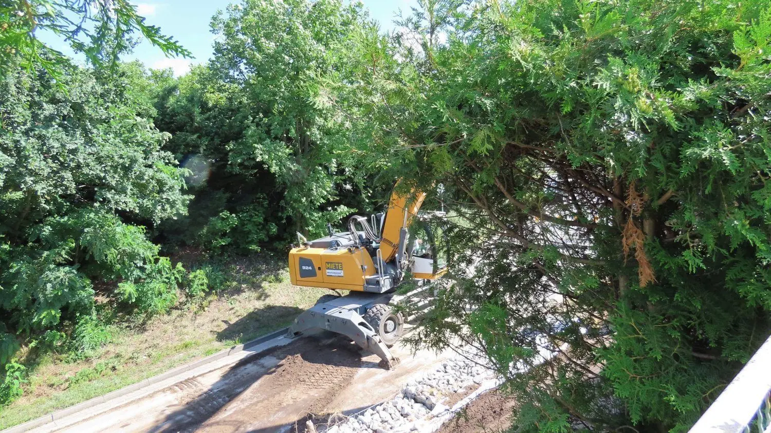 Hangsanierung an der L 52 zwischen Bühlow und Sellessen: Blick vom Gartenzaun die Böschung auf die Bühlower Straße hinunter: Für die Restarbeiten wird die Vollsperrung aufgehoben und der Arbeitszeit eine Bauampel regeln, dass die Autofahrer wieder mit Tempo 30 vorbei können.