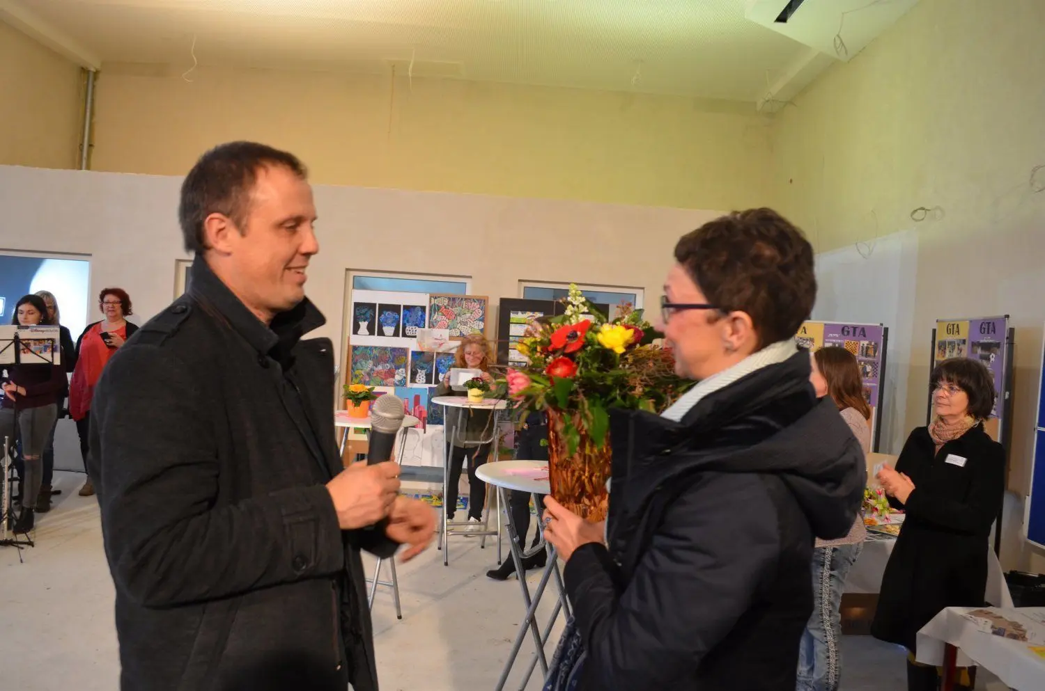 Hoyerswerdas neuer Bürgermeister Mirko Pink überreicht Schulleiterin Romy Stötzner einen Blumenstrauß.