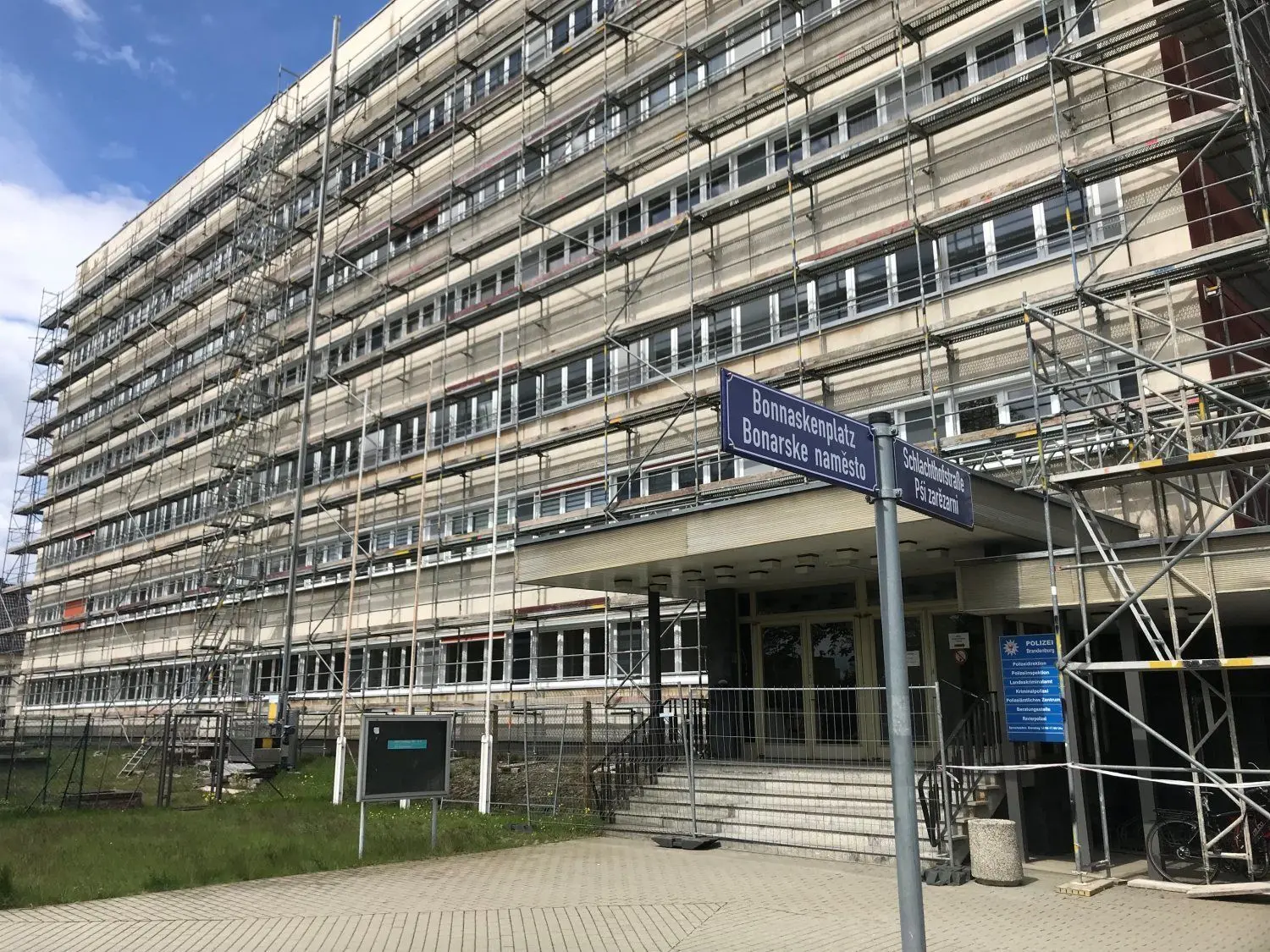 Ein Baugerüst umgibt das Haus am Cottbuser Bonnaskenplatz, in dem Polizeibeamte arbeiten.