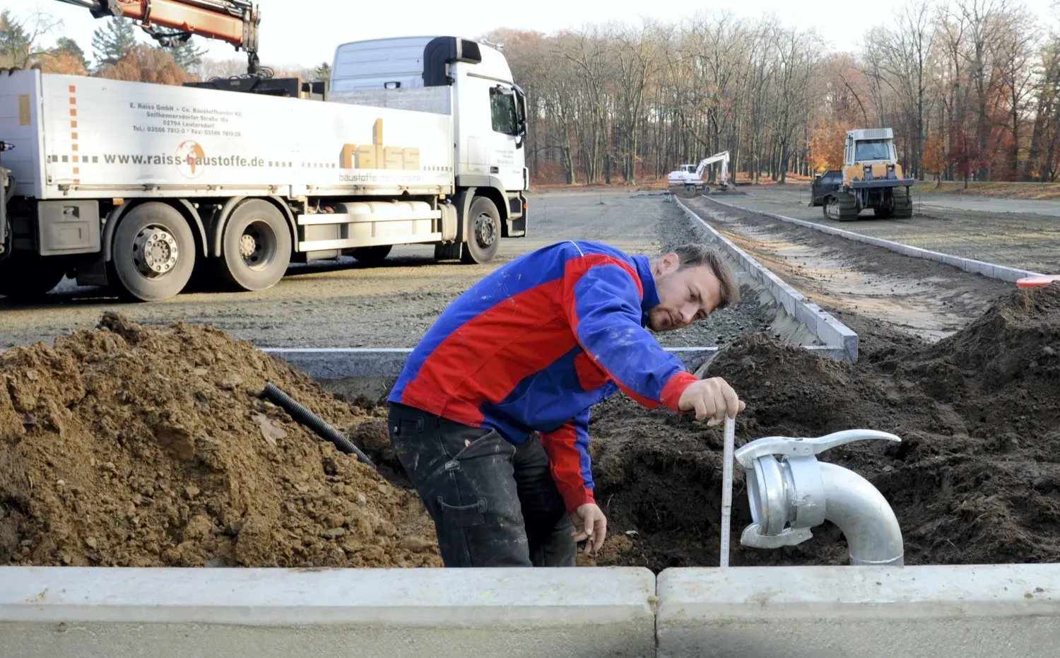 Bauleiter Florian Schellack von der Firma Eurovia Cottbus kontrolliert das Standrohr für die Entwässerung vom Parkplatz. Die Parkfläche wird planiert, die zweite Zufahrt ist bereits markiert.